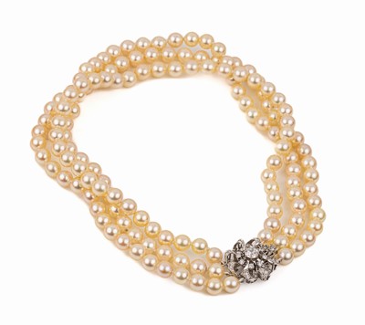 3-reihiges Zuchtperl-Collier-de-Chien mit 18 kt Gold Schließe, WG 750/000 in Form einer Blüte, cremefarb. sehr schöner Lüster, D. ca. 7.5 - 8 ...
