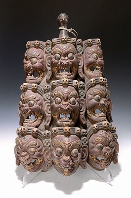 Wandapplike, Nepal/Tibet, 20. Jh., Holz geschnitzt mit 9 Mahakala-Gesichtern und Totenköpfen, Rot und Weiß gefaßt, ca. 46x30cm