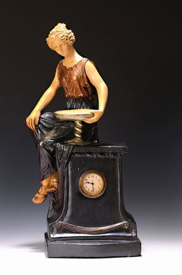 Tischuhr, Jugendstil, wohl Royal Dux Böhmen, um 1920/30, Gipsgehäuse im Stil der Zeit, auf Postament sitzende junge Frau im antiken Gewand,eine ...