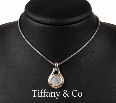 TIFFANY & CO. Perlmutt-Anhänger, 925er Silber und GG 750/000, Perlmuttscheibe in Goldreif gefasst, an Kette, L. ca. 40 cm, orig. Säckchen