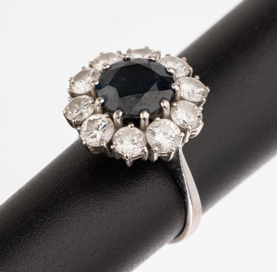 18 kt Gold Saphir Brillant Ring, WG 750/000, rundfacett. Saphir ca. 2.20 ct umgeben von 10 Brillanten zus. ca. 1.80 ct Weiß/si, RW 46, ca. 4.5 g