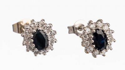 Paar 14 kt Gold Saphir-Diamant-Ohrstecker, WG 585/000, je mit einem ovalfacett. Saphir zus. ca. 1.0 ct umgeben von je 12 Diamanten zus. ca. 0.48 ct ...