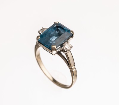18 kt Gold Farbstein Diamant Ring, WG 750/ 000, mittig rechteckig facett. blauer Farbstein, wohl Coelestin, 2 Diamanten zus. ca. 0.16 ct Weiß/si, ...