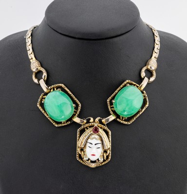 Collier, USA um 1950, Metall verg., Mittelteil mit emaillierten Damenkopf, 2 gr. Chrysoprascabochons, L. variabel ca. 37 - 46 cm, Hakenschließe, ...