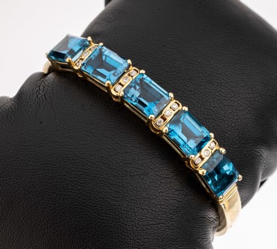 14 kt Gold Brillant-Topas-Armreif, GG 585/000, Mittelteil bes. mit 5 facett. Blautopase (beh.) zus. ca. 20.0 ct, im Wechselmit 12 Brillanten zus. ...