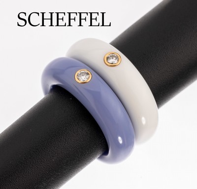 Set 2 SCHEFFEL Brillant-Ringe, 1 x Ringschiene aus weissem Corian, 1 x aus fliederfarb. Corian, jeweils 1 in GG 750/000 gefasster Brillant, zus. ca. ...