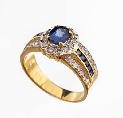 18 kt Gold Saphir-Diamant-Ring, GG/WG 750/ 000, mittig ovalfacett. Saphir ca. 0.85 ct, seitl. 10 facett. Saphircarrees zus. ca. 0.20 ct, umgeben von ...