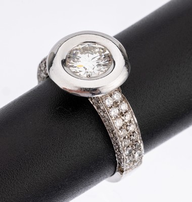 18 kt Gold Brillant-Ring, WG 750/000, mittig Brillant in gr. Zargenfassung ca. 1.0 ct l.get. Weiss/vs, Ringschultern mit 99 Brillanten zus. ca. 0.80 ...