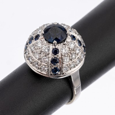 18 kt Gold Saphir-Brillant-Ring, WG 750/000, kuppelförm. Ringkopf, mittig erhaben gefasster rundfacett. Saphir ca. 1.30 ct, 12 rundfacett. Saphire ...