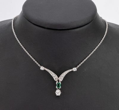 14 kt Gold Diamant-Smaragd-Collier, WG 585/000, geschwungenes Mittelteil, 1 bewegl. abgehängter Altschliffdiamant ca. 0.60 ct l.get.Weiß/si, 16 ...