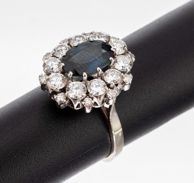 18 kt Gold Saphir-Brillant-Ring, WG 750/000, ovalfacett. Saphir ca. 1.80 ct, umgeben von 10 Brillanten und 10 kl. 8/8- Diamanten zus. ca. 1.70 ct ...