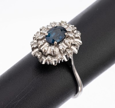 18 kt Gold Saphir-Diamant-Ring, WG 750/000,ovaler Ringkopf, mittig ovalfacett. Saphir ca.1.0 ct, umgeben von 24 8/8-Diamanten zus. ca. 0.12 ct ...