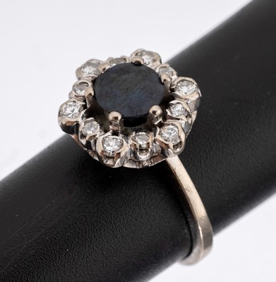 18 kt Gold Saphir-Brillant-Ring, WG 750/000, rundfacett. Saphir ca. 1.0 ct, umrahmt von Brillanten zus. ca. 0.30 ct Weiß/si, RW 50, ca. 4.5 g