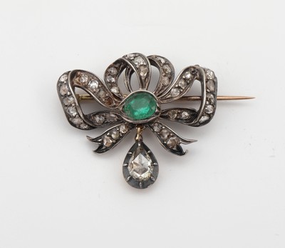 18 kt Gold und Silber Diamant-Smaragd- Brosche, um 1830/40, GG 750/000 gepr., Schauseite zeittyp. in Silber gearbeitet, Schleifenform mittig 1 ...