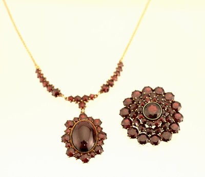 8 kt Gold Granat-Collier, GG 333/000, Mittelteil mit bewegl. Abhängung, gr. ovaler Granat-Cabochon umgeben von rundfacett. Granaten, L. ca. 45 cm, ...
