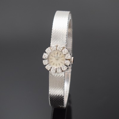 EXQUISIT Damenarmbanduhr in WG 750/000 mit Diamantlünette, Schweiz um 1965, Handaufzug, Boden aufgedr., silb. Zifferbl. m. silb. Std.-Ind. u. ...