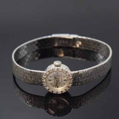 REUSSER diamantbesetzte Damenarmbanduhr in WG 750/000, Schweiz um 1960, Handaufzug, 2- teil. Geh. m. aufgedr. Boden, anges. Band, silb. Zifferbl. m. ...