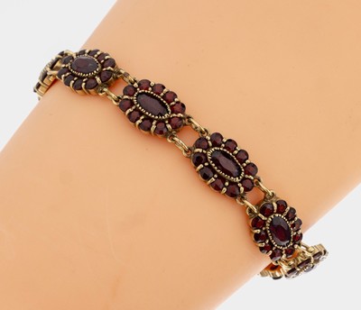 14 kt Gold Granat-Armband, GG 585/000, besetzt mit oval und rundfacett. Granaten, 1 Stein fehlt, L. ca. 19 cm, ca. 24.7 g, Kastenschloss, mit ...