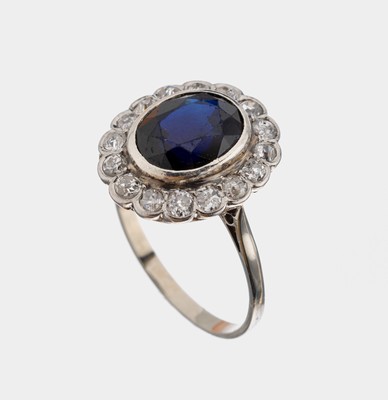 14 kt Gold Saphir-Diamant-Ring, um 1920-30, WG 585/000 gepr., mittig ovalfacett. Saphir ca. 1.50 ct, umgeben von 16 Altschliffdiamanten zus. ca. 0.80 ...