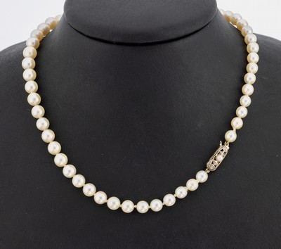 Lange Akoyazuchtperlenkette, an 14 kt Gold Schmuckschließe, cremef. Perlen im Verlauf,D. ca. 5.1 - 8.6 mm, WG Schließe mit Perle undDiamanten, ...