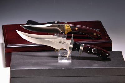 Zwei Jahresmesser der Waffenschmiede Magnum, 1994 und 1999, Griffschalen Holz, speziell geformte Klingen, Lederscheiden, beide in orig. Etuis, L. ca. ...
