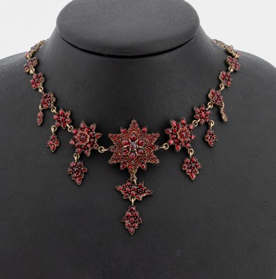 Granat-Collier, um 1880, Tombak, blütenf. Glieder, reicher Besatz mit facett. Granaten in versch. Formen und Größen, 1 Stein fehlt, nicht ...