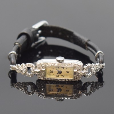 Art-Deco Damenarmbanduhr mit Diamanten in Platin, Schweiz um 1920, Handaufzug, Scharniergeh., Lünette sowie Bandanstöße aufw. m. Diamanten bes., ...