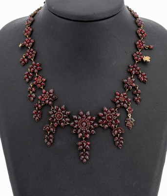 Granat-Collier, Böhmen um 1880/90, Tombak verg., facett. Granate von intensiver Farbe, blütenförm. Elemente, bewegl. Abhängungen, L. ca. 50 cm, ...