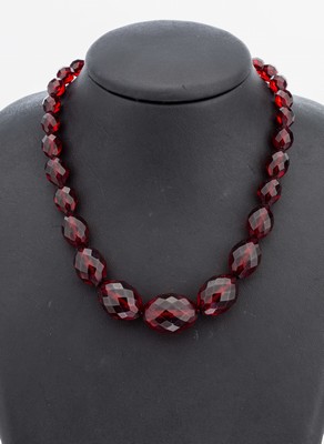 Bernsteincollier, um 1930, rote facett. Bernsteinoliven im Verlauf, L. ca. 8.7 - 23.4 mm, L. ca. 59 cm, Schraubschließe Metall