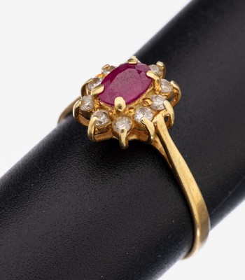 18 kt Gold Rubin-Brillant-Ring, GG 750/000,mittig erhaben gefasster rundfacett. Rubin ca.0.60 ct (grav.), 10 Brillanten zus. ca. 0.25 ct (grav.) ...