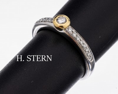 18 kt Gold H. STERN Brillant-Ring, WG/GG 750/000, 1 in GG gefasster Brillant ca. 0.07 ct Weiß/si, Schultern mit 16 Brillanten zus. ca. 0.08 ct ...