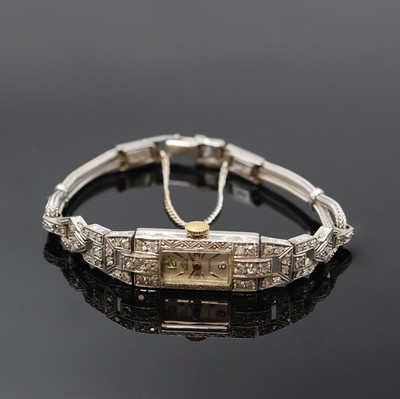 Art-Deco Damenarmbanduhr in Platin mit Diamanten, Schweiz um 1920, Handaufzug, Geh. grav., Scharnierboden, Lünette sowie Bandanstöße aufw. m. ...