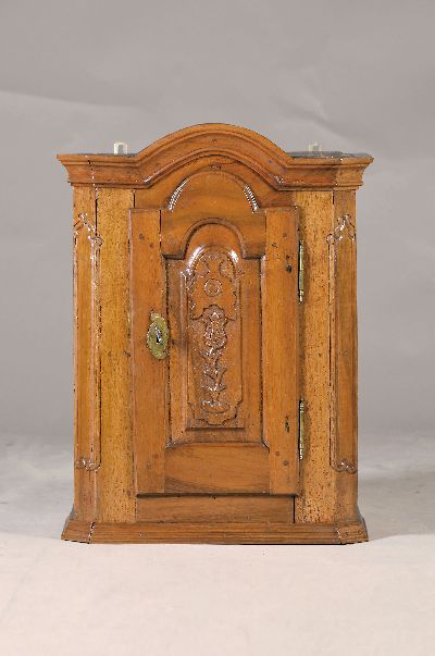 Hängeschränkchen, Barock, um 1760, Nussbaum massiv, leicht abgeflachte Seiten, kassettierte Tür mit floraler Schnitzerei, ca. 65 x 49 x 28.5 cm, ...