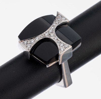 18 kt Gold Onyx-Brillant-Ring, WG 750/000, außergewöhnliche Gestaltung, konvexe Onyxplatte, verschraubte Montur, aufgelegtes WG-Ornament mit 19 ...