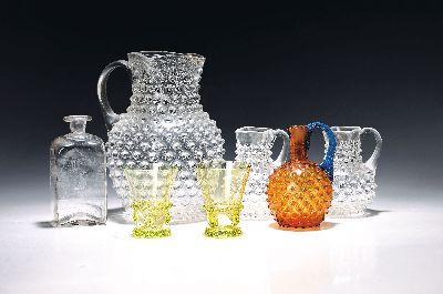 13-tlg Gläserlot, deutsch, meist 19. Jh., großer und 6 kleine, farblose Noppenkrüge, H. ca. 24/13 cm, bernsteinfarbener Noppenkrug mit blauem ...