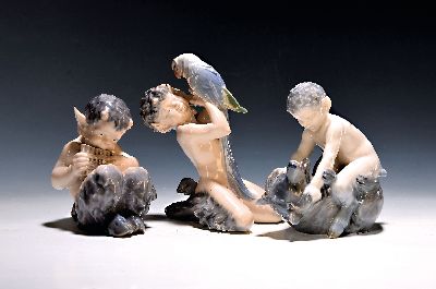 Drei Porzellanfiguren, Royal Copenhagen, 20. Jh., Unterglasurbemalung, sitzender Faun mit Panflöte, H. ca. 13 cm, sitzender Faun mit Bär spielend, ...