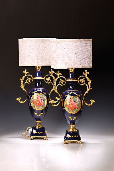 Paar Tischlampen, Frankreich, 1960er/70er J., Korpus Porzellan kobaltblau glasiert, vergoldete Metallmonturen, in Kartuschen bunt lithographierte ...