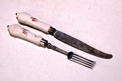 2tlg-Besteck, Meissen, um 1750, Porzellangriffe mit Blumendekor, berieben, Metallmontur, Monturringe ergänzt, Messer und Gabel, L. ca. 20.5-22.5 cm, ...