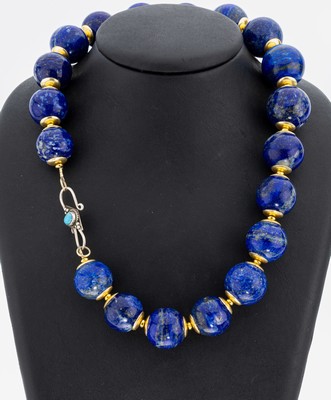 Lapislazuli-Collier, im Verlauf Lapislazuli-Kugeln, D. ca. 18.6-22.1 mm, Zwischenglieder Messing vergoldet, L. ca. 49 cm, S-Schließe Silber mit kl. ...