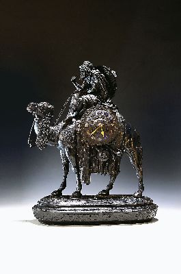 Pendule, Frankreich, um 1900, Reich verzierter Metallguss, Bekrönung eines Kamels mit Beduine, Applikation in Hand fehlt, wohl ehemals auf ...