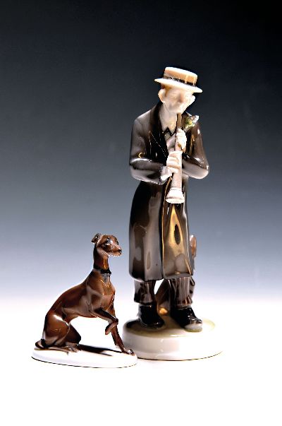 Zwei Figuren Rosenthal, Kriegsmarke und, um 1920, Klarinettenspieler, 1914-18, am Hut min. best., H. ca. 20.5 cm, dazu Jagdhund, K 289, auf ovalem ...