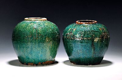 Zwei grün glasierte Vasen, China, 19./20.Jh. , rotbrauner Scherben, grüne Glasur, Schultern mit Reliefdekor, l. best., H. 20 cm