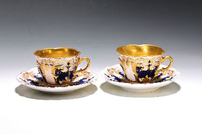 2 Tassen mit Untertassen, Meissen, um 1870, 1. Wahl, reich reliefiert, partiell kobaltblau glasiert, matt- und glanzvergoldet, berieben, H. ca. 7cm