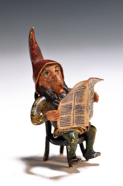 Wiener Bronze, Zwerg mit Zeitung, 20.Jh., Bronze, farbig staffiert, auf einem Stuhl sitzender Zwerg mit Zeitung, H. 7 cm, Wasserkrug-Stempel