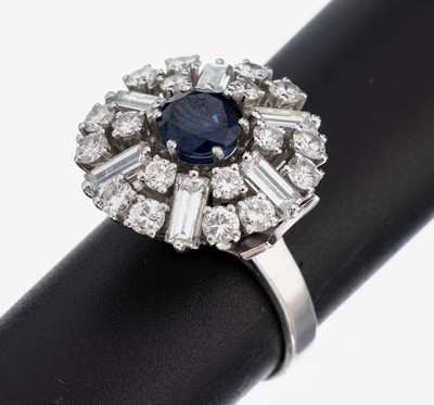 18 kt Gold Saphir-Diamant-Ring, 1970er Jahre, WG 750/000, runder Ringkopf, mittig rundfacett. Saphir ca. 1.25 ct, 18 Brillanten und 6 ...