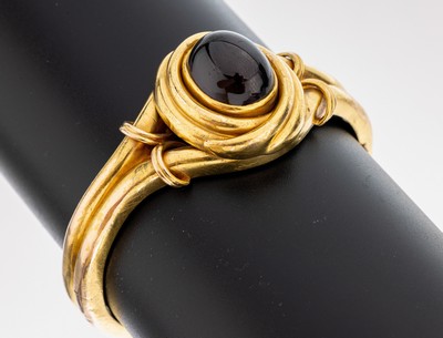18 kt Gold Granat Armreif, um 1880, GG 750/000, mittig Granatcabochon, rücks. urspr. Medaillon (Verglasung fehlt), Klappscharnier mit ...