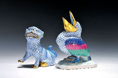 2 Porzellanfiguren, Herend Ungarn, 20. Jh., bunt bemalt mit blauem Fischnetzmuster und Goldstaffage, Fo-Hund H. ca. 15cm, Pelikan H. ca. 21cm