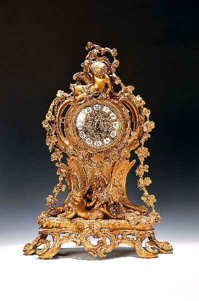 Tischuhr, deutsch um 1950/60, reich verziertes Messinggehäuse, Sockel mit Rocaillen mit Durchbrucharbeit, Bekrönung des Bacchus, unter Uhr Hirte ...