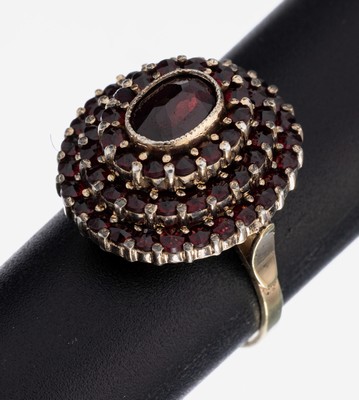 14 kt Gold Granat-Ring, GG 585/000, Aufbau in mehreren Ebenen, mittig ovalfacett. Granat umgeben von rundfacett. Granaten, RW 61, ca. 7.7 g