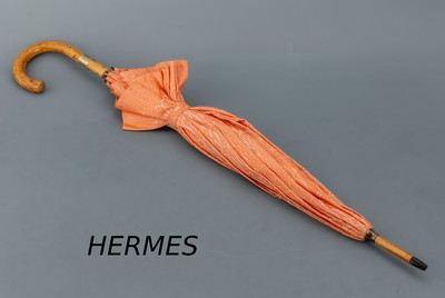 HERMES Schirm, Paris, lachsfarb. mit H Emblemen, Holzrahmen, Messingdetails, L. ca. 89 cm, D. im aufgeklappten Zustand ca. 96 cm